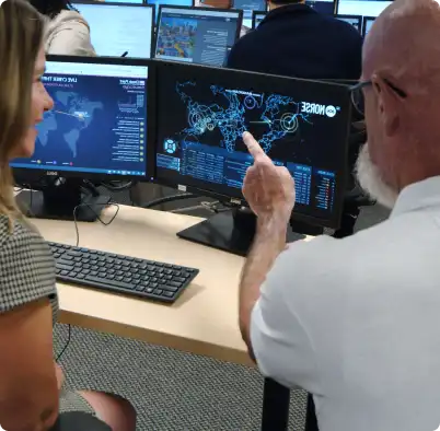 man instructing woman pointing at computer