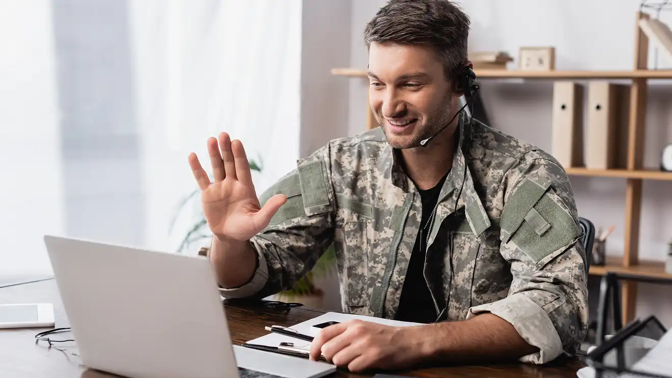 veteran in fatigues on laptop call