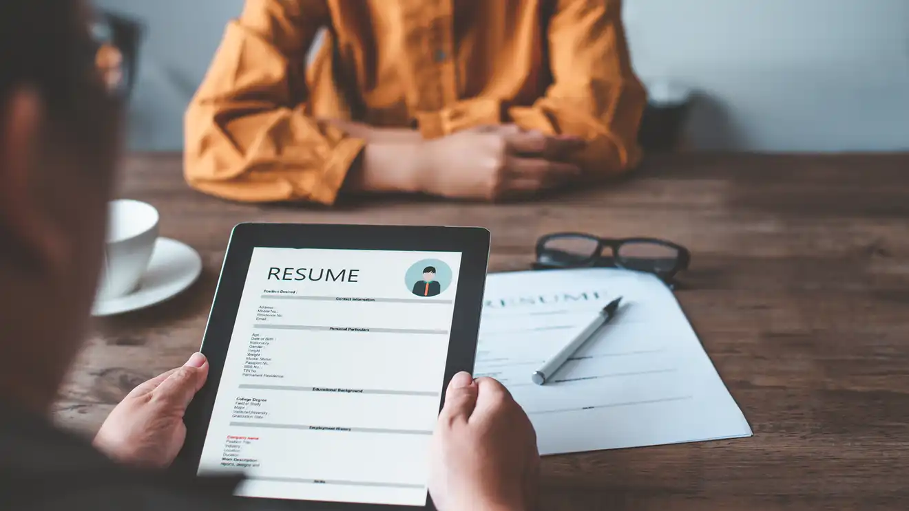 hands holding ipad that says resume