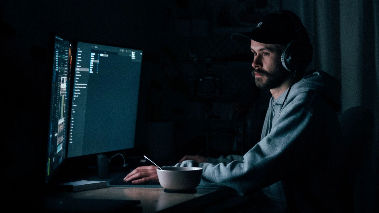 Person programming in a dimly lit room