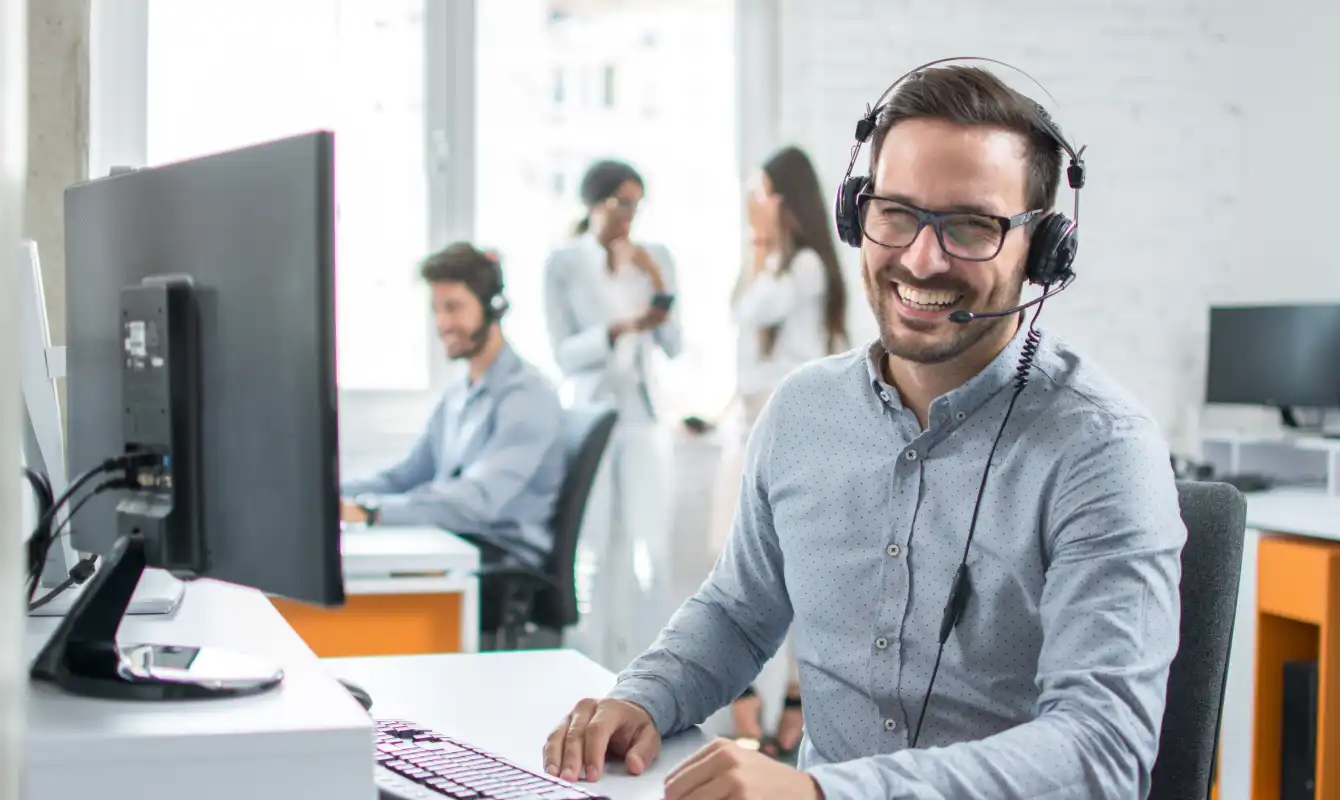 happy man with headset using desktop computer