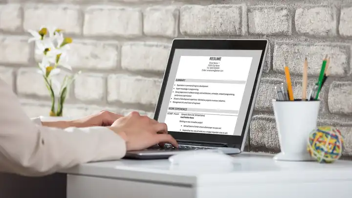 white brick wall with laptop in foreground that says resume at top