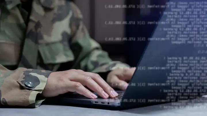 hands with fatigues on, fingers on laptop