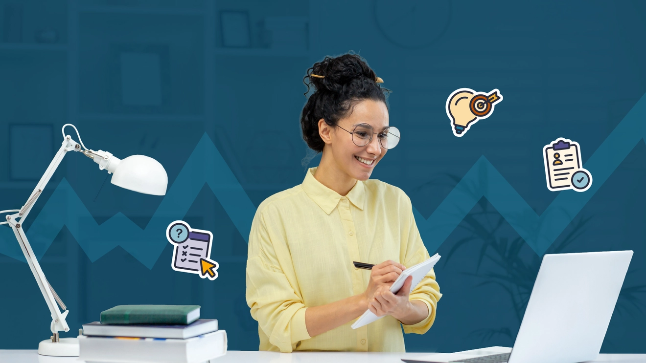 Woman taking notes while looking at a computer screen with floating graphics, preparing to take the PMI-PBA certification exam